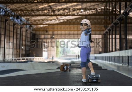 surfskate by asian child skater or kid girl smile start riding surf skate at pump track or fun playing skateboard in skate park by extreme sports surfing to wearing helmet wrist knee guard body safety Royalty-Free Stock Photo #2430193185