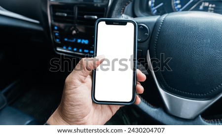 Close-up image of Driver hand using blank white screen mobile smart phone inside a car. Man looking at smartphone screen searching location via gps navigator application