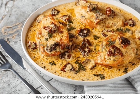 Marry Me Chicken with sun-dried tomatoes, cheese, herbs and aromatic creamy sauce close-up in a plate on a marble table. Horizontal
 Royalty-Free Stock Photo #2430205941