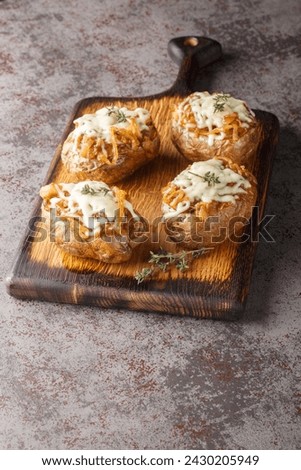 Twice baked potatoes stuffed with French onions and Gruyere cheese close-up in a bowl on the table. Vertical
 Royalty-Free Stock Photo #2430205949
