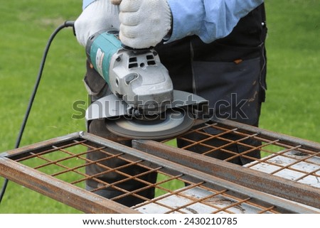 Cleaning metal in places of electric welding using a flap disc for an angle grinder Royalty-Free Stock Photo #2430210785