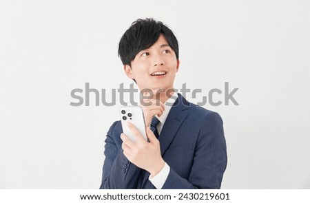 Asian businessman with the smartphone thinking in white background