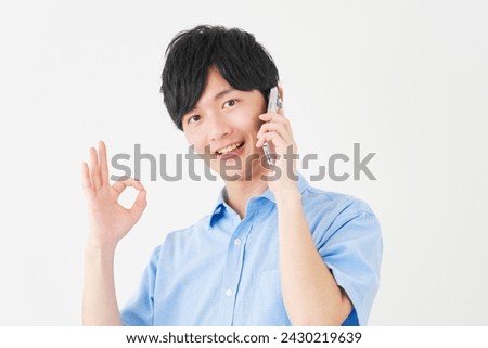 Asian man with the smartphone OK gesture in white background