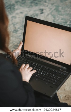 Close up photo of woman in black suit is looking at a laptop at home. Freelance and remote work. Modern female lifestyle. Copy space for text