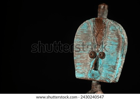 Close up of a wooden Kota reliquary figure from Gabon, isolated on a black background. Tribal African art, showcasing masterful craftsmanship and spiritual symbolism. Royalty-Free Stock Photo #2430240547