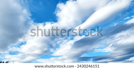 Giant stratus clouds stretch across the vast blue sky, resembling thick sausages, a fantastic display of natural wonder. Transparent air enhances the breathtaking spectacle