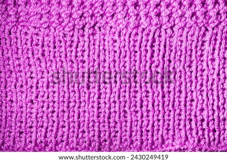 Knitted surface. Knitted fabric texture. Warm knitwear. Wool pattern. Haberdashery close-up