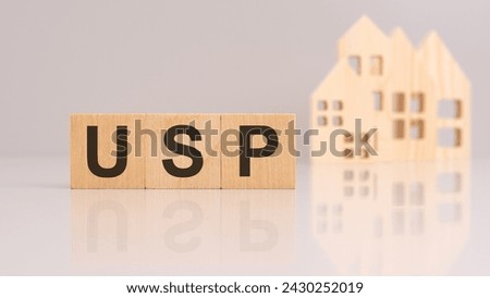 acronym USP stands for 'Unique Selling Proposition' on wooden cubes with models house on background.