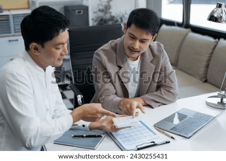 Businessman and partner using calculator and laptop for calculation finance, tax, accounting, statistics and analytic research concept. in the office.