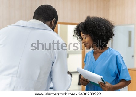 Black curly hair nurse woman talking with black doctor in hospital