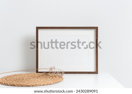 Horizontal wooden poster frame in white interior, mockup for picture, print or photo frame presentation