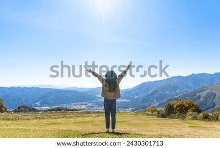 Mountaintop traveler enjoying tourist adventure travel freedom, mountaineering nature height, breathtaking activity of outdoor hill top trip with panoramic view of mountain peak and sky horizon Royalty-Free Stock Photo #2430301713