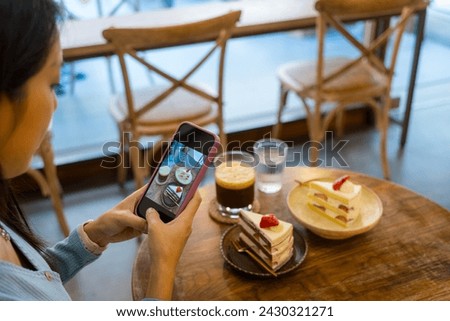 Woman take photo on the strawberry cake in coffee shop