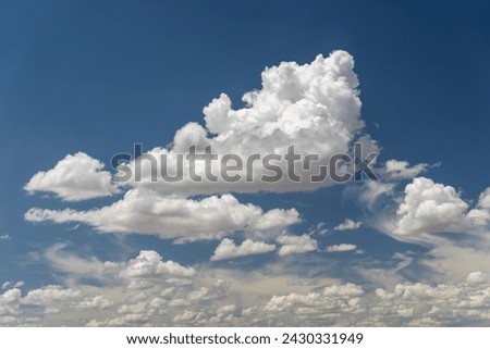 Large, white cumulus cloud in a clear blue sky Royalty-Free Stock Photo #2430331949