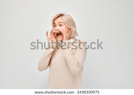Portrait of blonde girl shouting loudly with hands, news, palms folded like megaphone isolated on white background Royalty-Free Stock Photo #2430350975