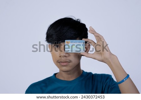 Semarang, Indonesia - June 4, 2023: A person shows and holds Indonesian identity cards (KTP). Selective focus