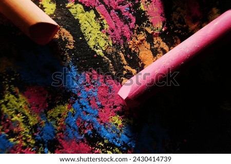 Pastel colored abstract chalk mix of blue, yellow and pink on a dark textured stone surface Royalty-Free Stock Photo #2430414739