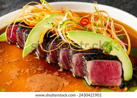 tuna tataki with vegetables and sauce on white plate Royalty-Free Stock Photo #2430421901