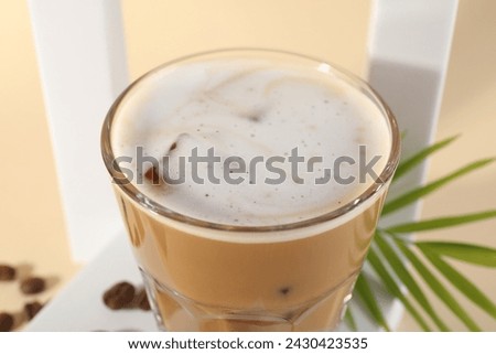 Refreshing iced coffee with milk in glass on table, closeup
