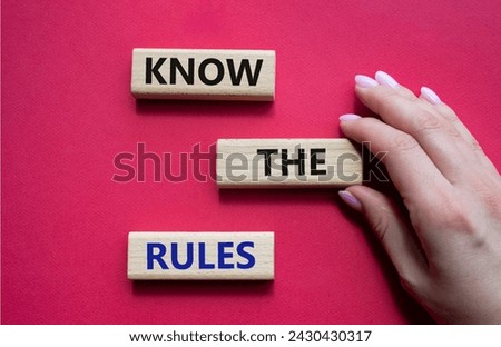 Know the rules symbol. Wooden blocks with words Know the rules. Beautiful red background. Businessman hand. Business and Know the rules concept. Copy space.