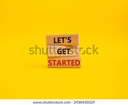 Lets get started symbol. Concept words Lets get started on wooden blocks. Beautiful yellow background. Business and Lets get started concept. Copy space.