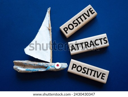 Positive attracts Positive symbol. Wooden blocks with words Positive attracts Positive. Beautiful deep blue background with boat. Business concept. Copy space. Royalty-Free Stock Photo #2430430347
