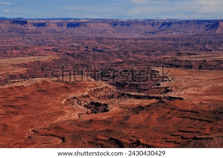 A bird's-eye view of the harsh, eroded canyon lanscape of the Colorado Plateau from the Mesa Arch viewpoint, Canyonlands National Park, Moab, Utah, Southwest USA. Royalty-Free Stock Photo #2430430429