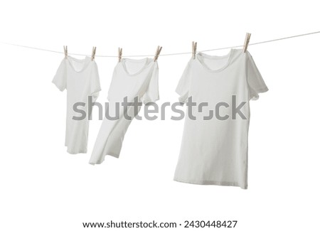 Many t-shirts drying on washing line isolated on white Royalty-Free Stock Photo #2430448427