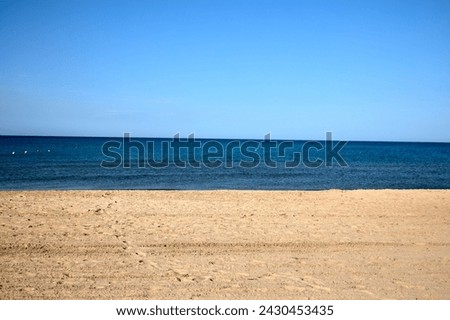 view of the blue black sea from the beach, summer, wind, creates drawings on the sand. lots of shells