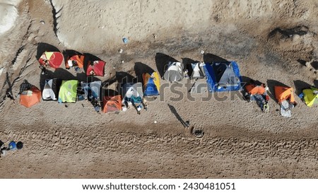 Beach bliss: A diverse group stands in line, casting playful shadows on golden sands. Human connection, captured from above. Ideal for lifestyle concepts. Royalty-Free Stock Photo #2430481051