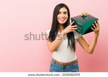 Attractive mexican young woman smiling showing her graduation cap after graduating university or college 