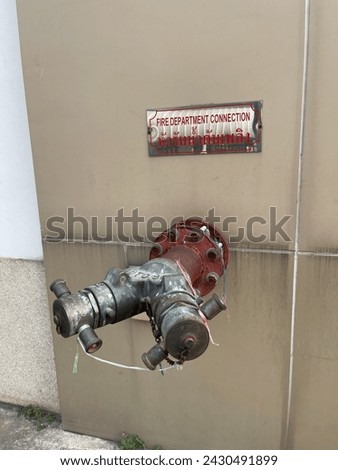 Old fire sprinkler next to the wall and warning sign