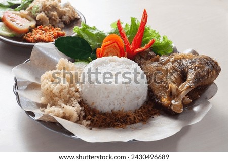Ayam Bakar Kremes or Crunchy grilled chicken served with white rice and spicy chili vegetables
