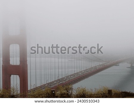 A foggy distant photo of the Golden Gate Bridge. A early morning image from a high up look out to bring in cozy, relaxed, and dreamy aesthetic to any project.