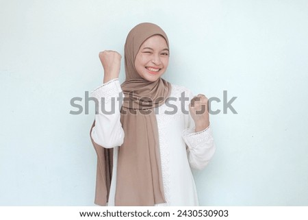 Young Asian Muslim woman wearing hijab, sweet smiling and see camera with happy successful or excited expression, Isolated in gray background. Royalty-Free Stock Photo #2430530903
