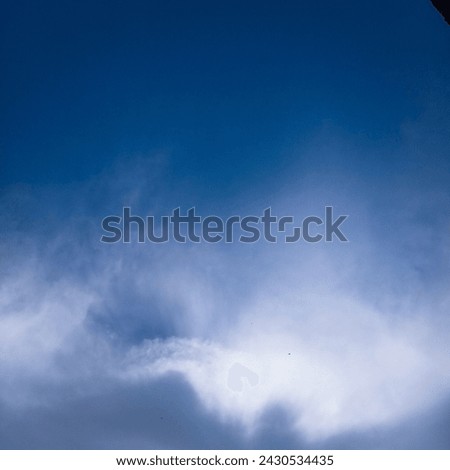 Blue sky and sun hidden in clouds 