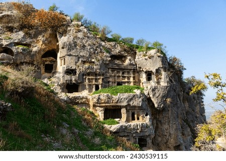 Lycian graves carved into mountainside in ancient settlement of Tlos located near Fethiye town in Turkey Royalty-Free Stock Photo #2430539115
