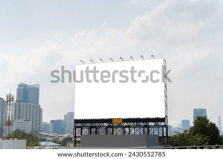 The image shows a large blank billboard in the middle of a cityscape. Tall buildings and traffic can be seen in the background. Advertising and the power of visual communication. Clipping path.