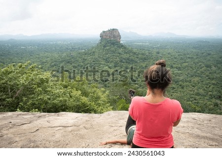 A photographer taking pictures of Sigiriya Rock Castle from the top of Pidurangala Rock in Sri Lanka.