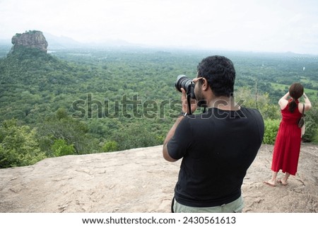Photographers taking pictures of Sigiriya Rock Castle from the top of Pidurangala Rock in Sri Lanka.
