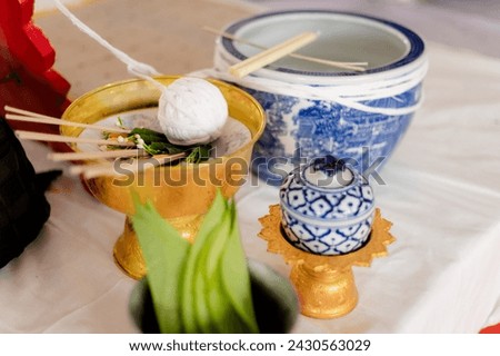 A golden tray with white thread is in the center of the picture.