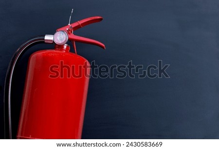 Fire extinguisher on dark background.