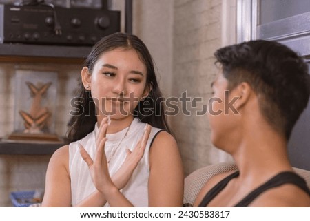 A young asian woman says no to her boyfriend requests to kiss her, setting her boundaries. Not ready for an intimate moment. Royalty-Free Stock Photo #2430583817