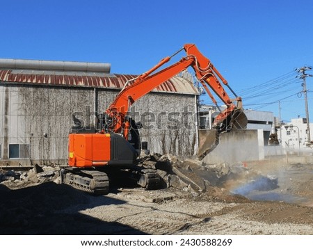 A heavy machine in operation at the demolition site.
The water used to keep dust down creates rainbow in the air.
After breaking down the building, it handles concrete debris. Royalty-Free Stock Photo #2430588269