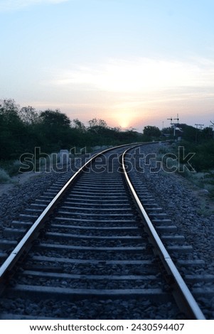 railway track India, a train track with a wire fence and trees in the background. railroad surrounded by trees at daytime