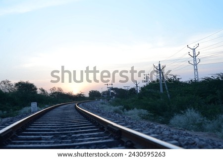 black metal train rail tracks, railway between tall trees. brown train rail near green grass field during daytime.
