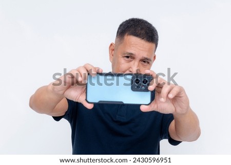 A middle aged asian man taking a landscape mode photo with his high-end smartphone. Advertisement of phone camera features and lens. Isolated on a white background.