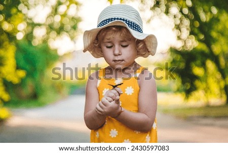 A child catches a butterfly in nature. selective focus. kid. Royalty-Free Stock Photo #2430597083