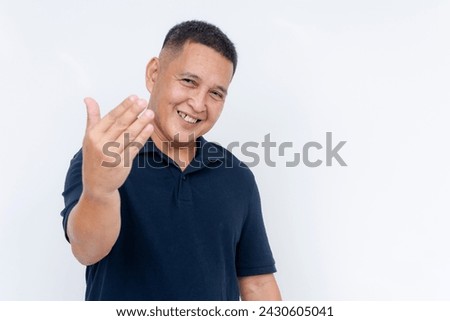 Welcoming middle-aged Asian man smiling and gesturing with his hand, isolated on a white background. Portraying warmth and friendliness. Royalty-Free Stock Photo #2430605041