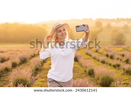 woman taking photo with mobile cell phone in the lavender field